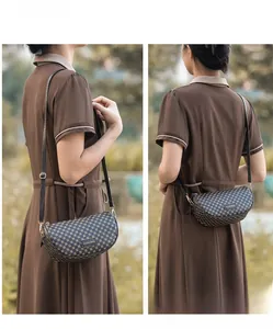 Detail view of small saddle bag with brown geometric print and gold metal buckle strap