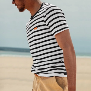 Detail of men's striped T-shirt with chest pocket and bright orange woven brand label