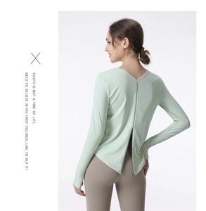 Detail view of mint green long sleeve sports top with open split back design for yoga