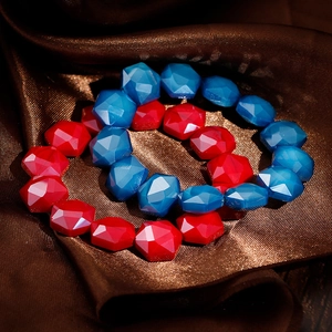 Detailed close-up of bohemian red and blue faceted crystal beaded bracelets on silk fabric