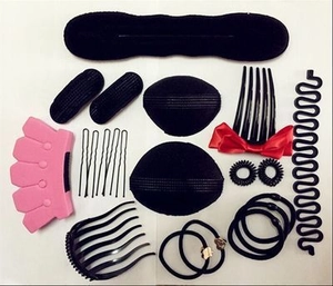 Macro shot of assorted black sponge hair styling tools and plastic combs set on white