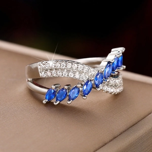 Detail of silver-toned ring featuring marquise-cut blue sapphire gems and white zircon accents