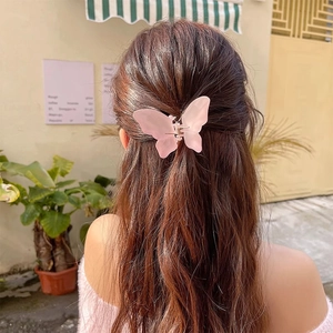 Pink frosted butterfly hair claw clip shown in a stylish half-up hairstyle
