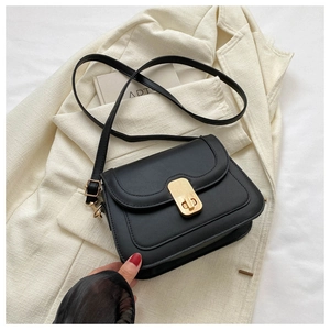 Close-up of black crossbody bag with gold metal clasp and premium stitching detail