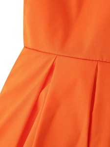 Détail macro de la taille de la robe orange montrant la texture plissée du tissu