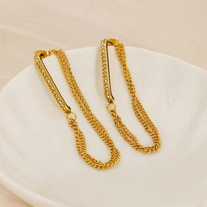 Detailed macro view of 18K gold double chain tassel earrings with sparkling rhinestones