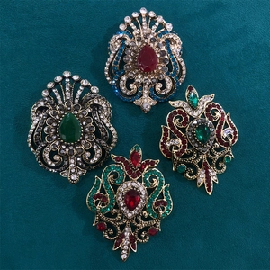 Detail of vintage palace style brooches with colorful rhinestones on dark velvet background