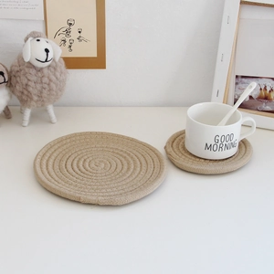 Detail of woven jute coasters and placemats on a white table in a cozy setup