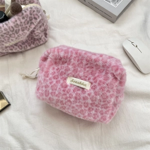 Detail of pink leopard plush makeup bag with soft faux fur texture and brand label