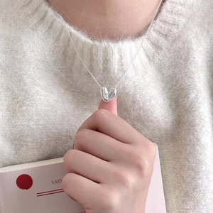 Detailed view of an irregular 925 silver heart pendant on a thin chain worn by a model