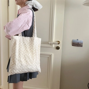 Detail of white floral lace tote bag showing the delicate mesh texture and soft patterns