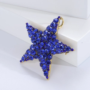 Detailed view of a star brooch with deep blue rhinestones on a vintage gold base