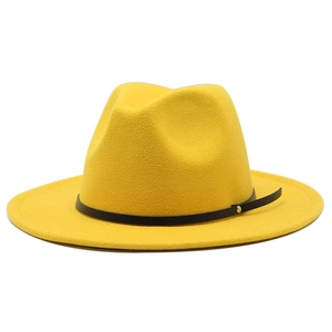 Detailed close-up of wide-brim yellow fedora hat with black leather band and gold rivet