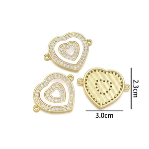 Macro detail of gold-plated heart pendant with mother of pearl and crystals, 2.3x3.0cm