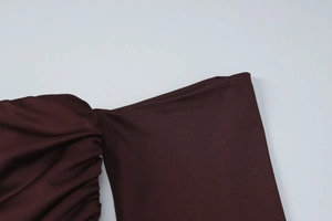 Detailed view of deep burgundy knitted fabric showing seams and textured shirring details