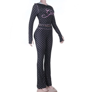 Detail of hooded top sleeve with thumbholes and white polka dot print on black fabric