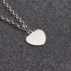 Silver titanium steel necklace with smooth heart pendant on a sparkling black background