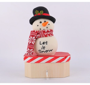 Mechanical snowman music box with Let it Snow script on a wooden decorative base