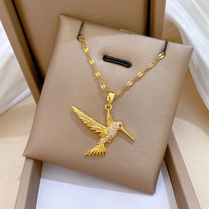 Close-up of gold hummingbird pendant with tiny diamonds in a jewelry box
