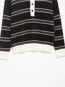 Close-up of polo neck button placket and striped knit texture on classic long sleeve sweater