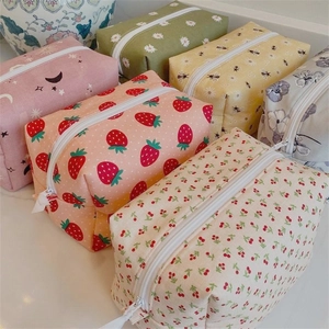 Detailed close-up of various patterned fabric toiletry bags stacked on a clean surface