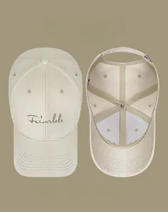 Detail of cotton baseball cap featuring metallic cursive embroidery and adjustable metal buckle