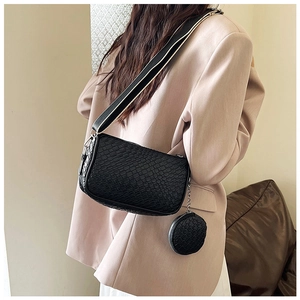 Detail of black faux crocodile leather bag with contrast woven strap and small pouch