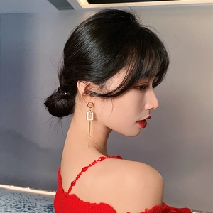 Elegant gold-tone asymmetric square tassel earrings with rhinestones shown on model