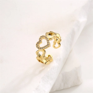Detail of gold open ring featuring hollow heart shapes and shimmering pavé zircons