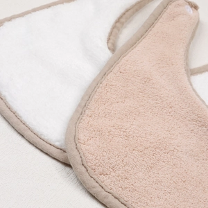 Detailed view of plush baby bibs showing soft texture and premium cotton piping edge