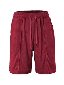 Detail of burgundy sweat shorts featuring textured geometric jacquard and drawstring waist