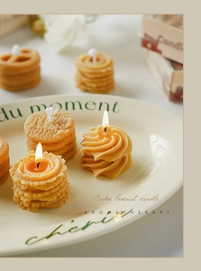 Primer plano de vela aromática con forma de galleta en bandeja de cerámica crema