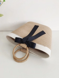 Handwoven beige cotton rope tote bag with black satin bow and circular handles