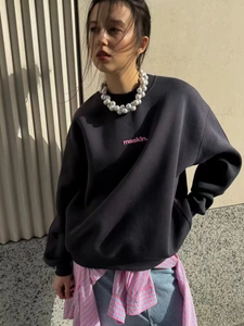 Charcoal grey oversized sweatshirt with pink letter print on a minimalist urban background