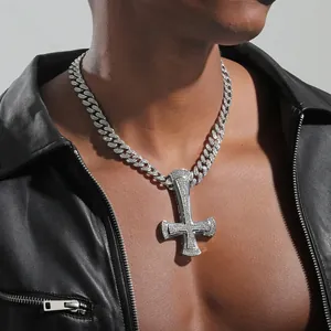 Detail of hip hop inverted cross pendant with white zircon stones on a Cuban chain