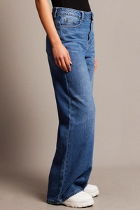 Vista laterale di jeans blu a vita alta con gamba larga che mostra la vestibilità