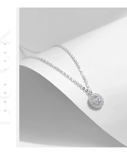 Macro shot of silver sterling circular pendant with sparkling cubic zirconia on white background
