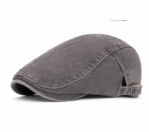 Detail of dark gray washed denim flat cap showing metallic side adjustment buckle