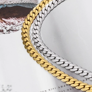 Macro detail of textured Cuban link necklaces in gold and silver stainless steel finish