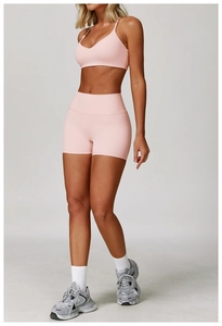 Dettaglio del set yoga rosa con reggiseno sportivo a V e pantaloncini a vita alta