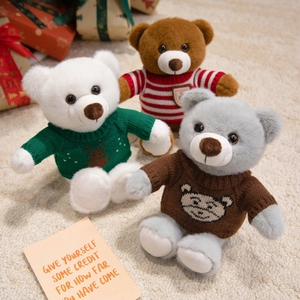 Trois ours en peluche avec pulls tricotés et coffrets cadeaux sur tapis doux