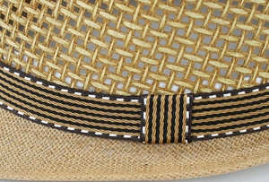 Macro detail of breathable mesh straw hat with tricolor striped ribbon trim and fine stitching