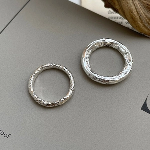 Detailed view of 925 sterling silver rings with irregular lava texture and glossy finish