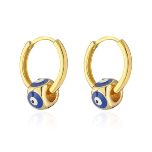 Close-up of gold-plated hoop earrings featuring blue enamel evil eye charms with reflection