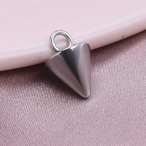 Macro shot of a conical stainless steel pendant with silver finish on a pink surface