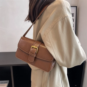 Brown vintage faux leather baguette shoulder bag with gold square buckle on a model