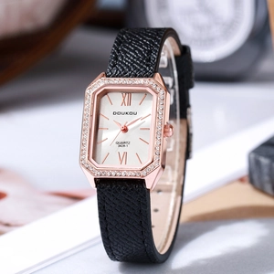 Detail of rose gold rectangular watch dial with rhinestones and black leather strap