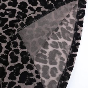 Close-up of semi-transparent leopard print mesh fabric with detailed stitching and texture