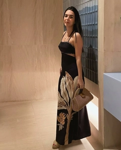 Close-up of black backless maxi dress with floral embroidery and side waist cutouts
