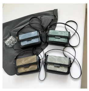 Detailed flat lay of small crossbody bags in blue, green, brown, and grey on a blazer